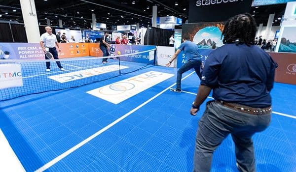 Attendees playing pickleball on a Community Summit North America expo floor
