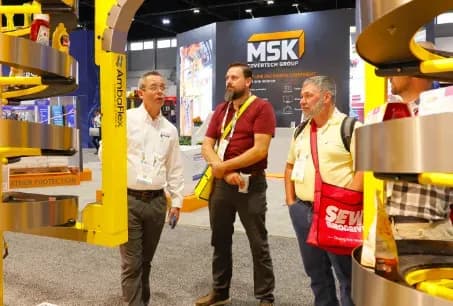 An exhibitor demonstrates packaging equipment to attendees at PACK EXPO International 2024 in Chicago.