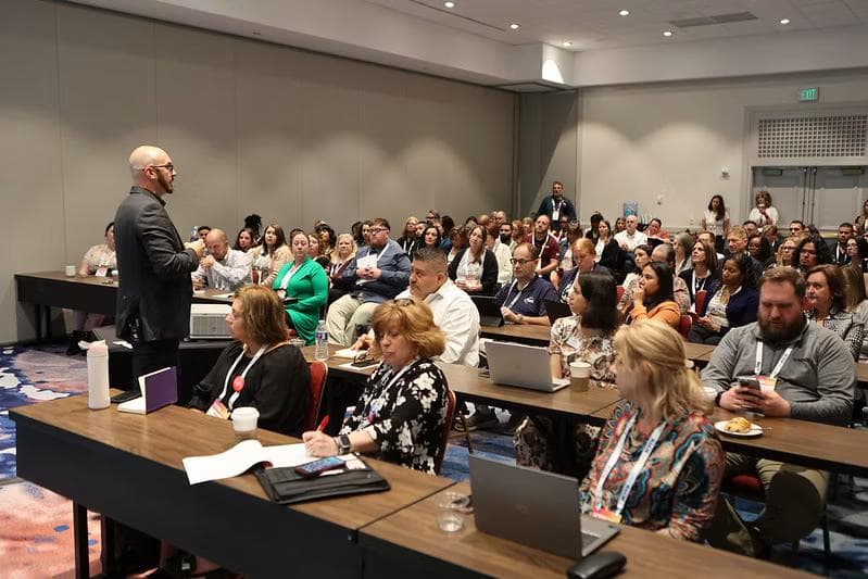 A speaker presenting to a full room of attendees at an ICMI Contact Center Expo breakout session