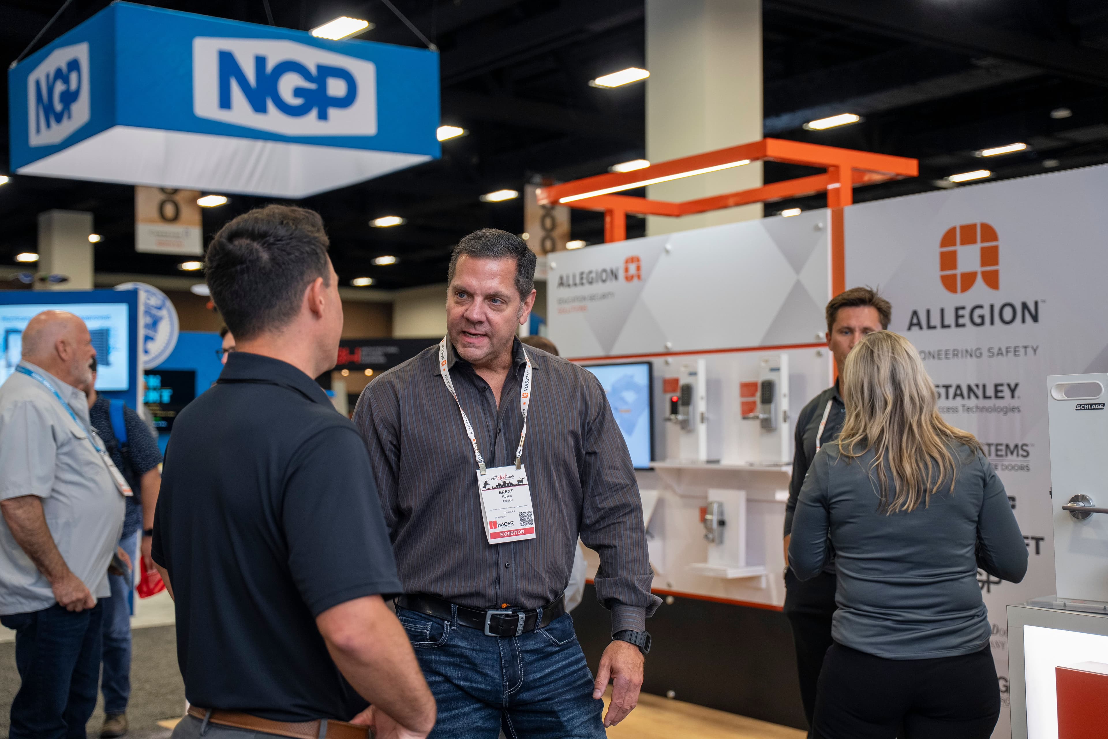 Attendees discuss commercial door hardware on the DHI conNextions 2025 exhibit floor