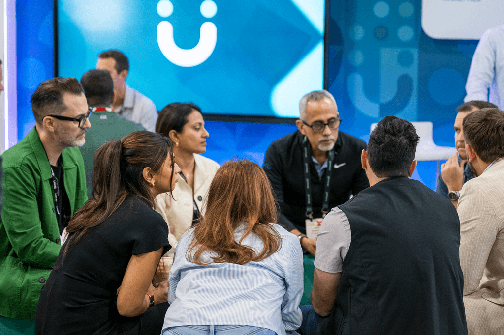 HR Tech 2025 attendees in a group conversation on the expo floor