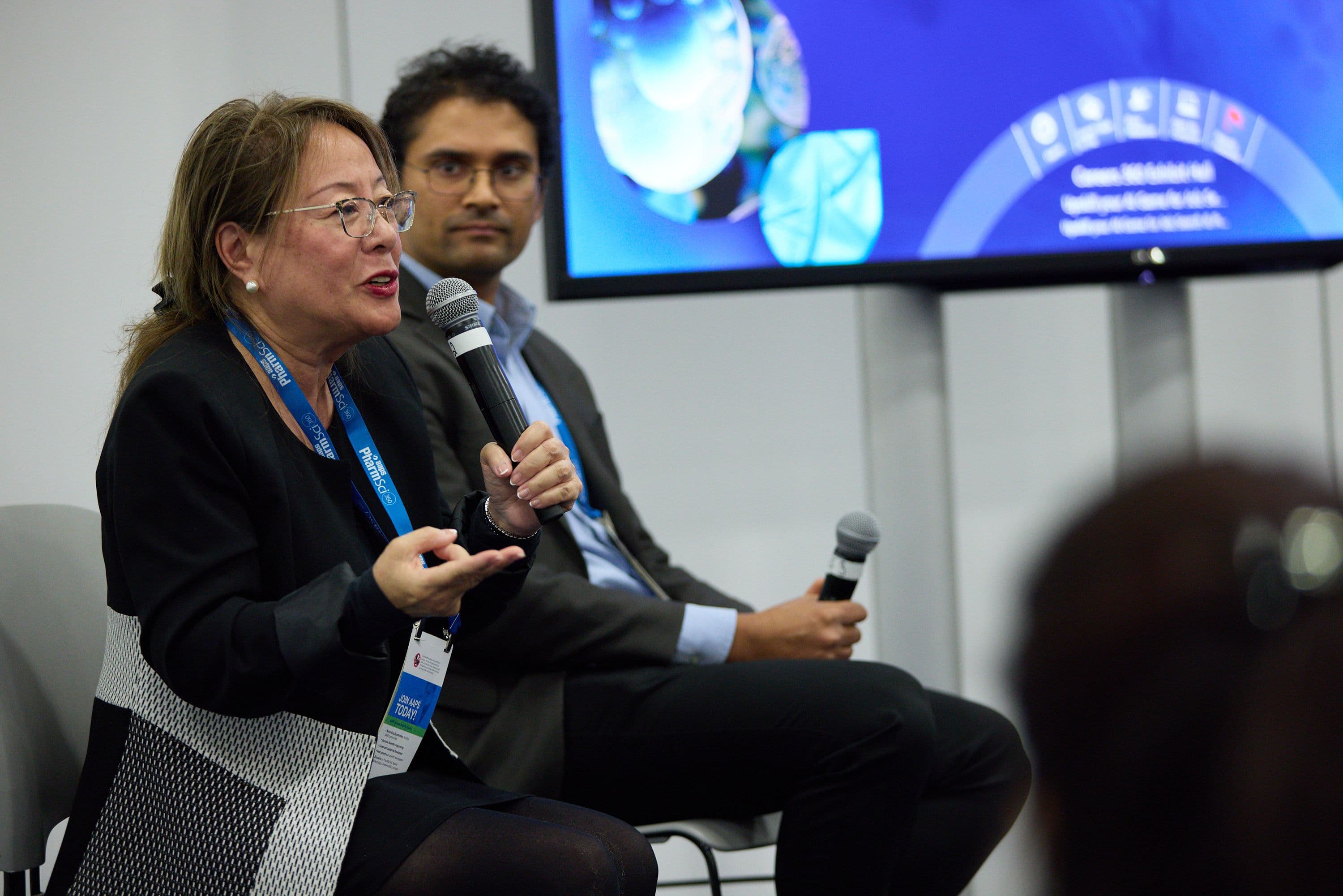 Two PharmSci 360 panelists speaking with microphones during a scientific session