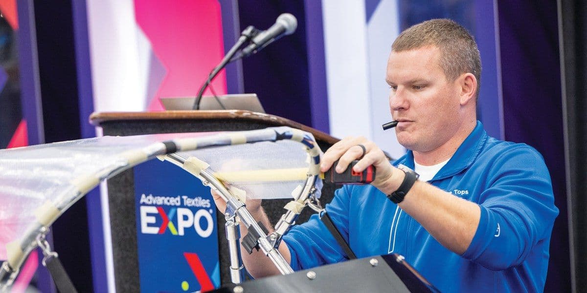 A fabricator operates machinery during Advanced Textiles Expo 2025