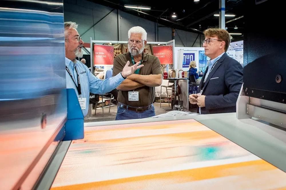 LOUPE Americas visitors discussing technology at an exhibition stand
