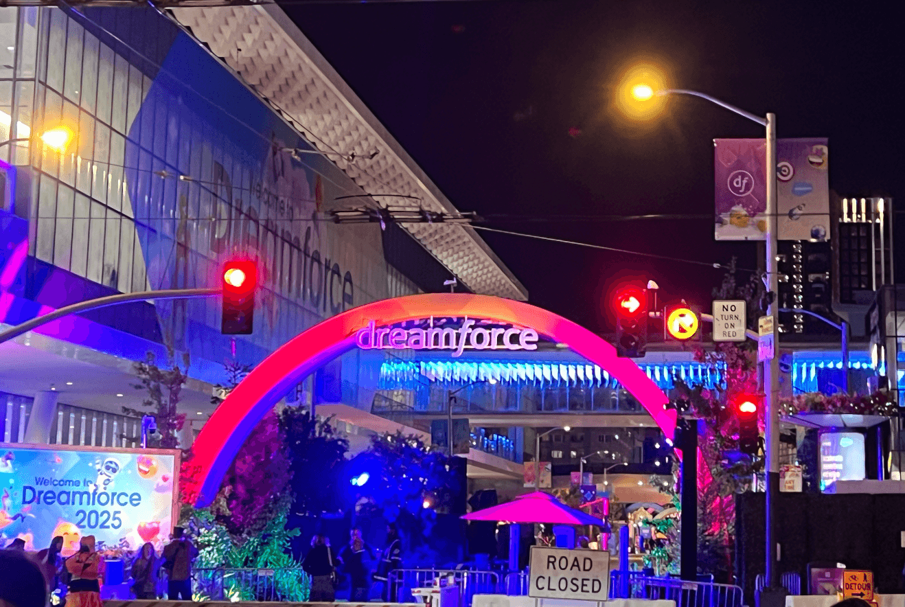 The illuminated red Dreamforce arch at the Moscone Center entrance at night.