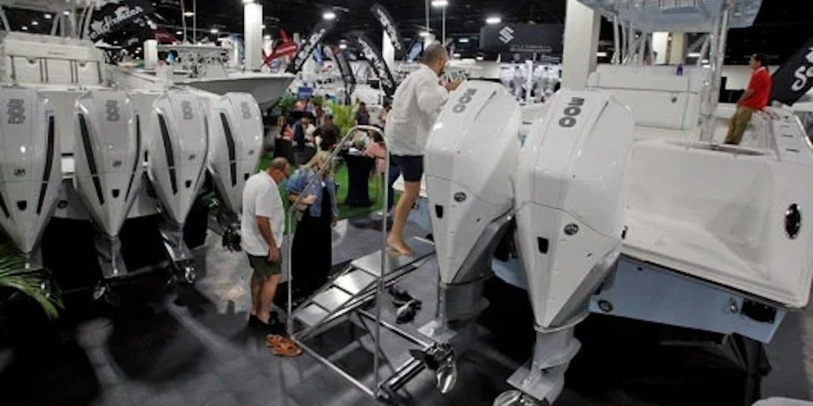 Visitors examining boats and engines at the Fort Lauderdale International Boat Show