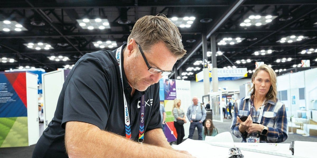 A participant works with textile material on the Advanced Textiles Expo 2025 floor