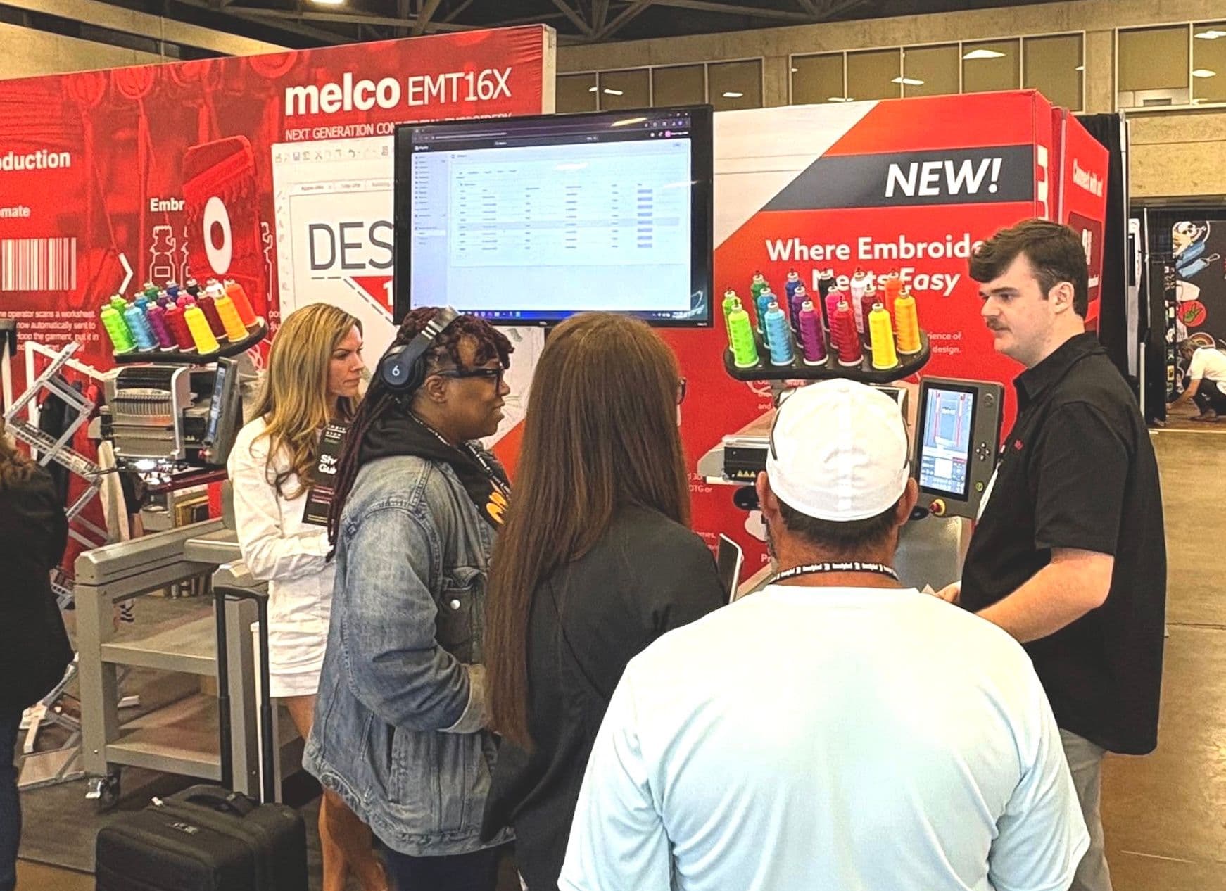 Attendees watch a Melco embroidery demonstration