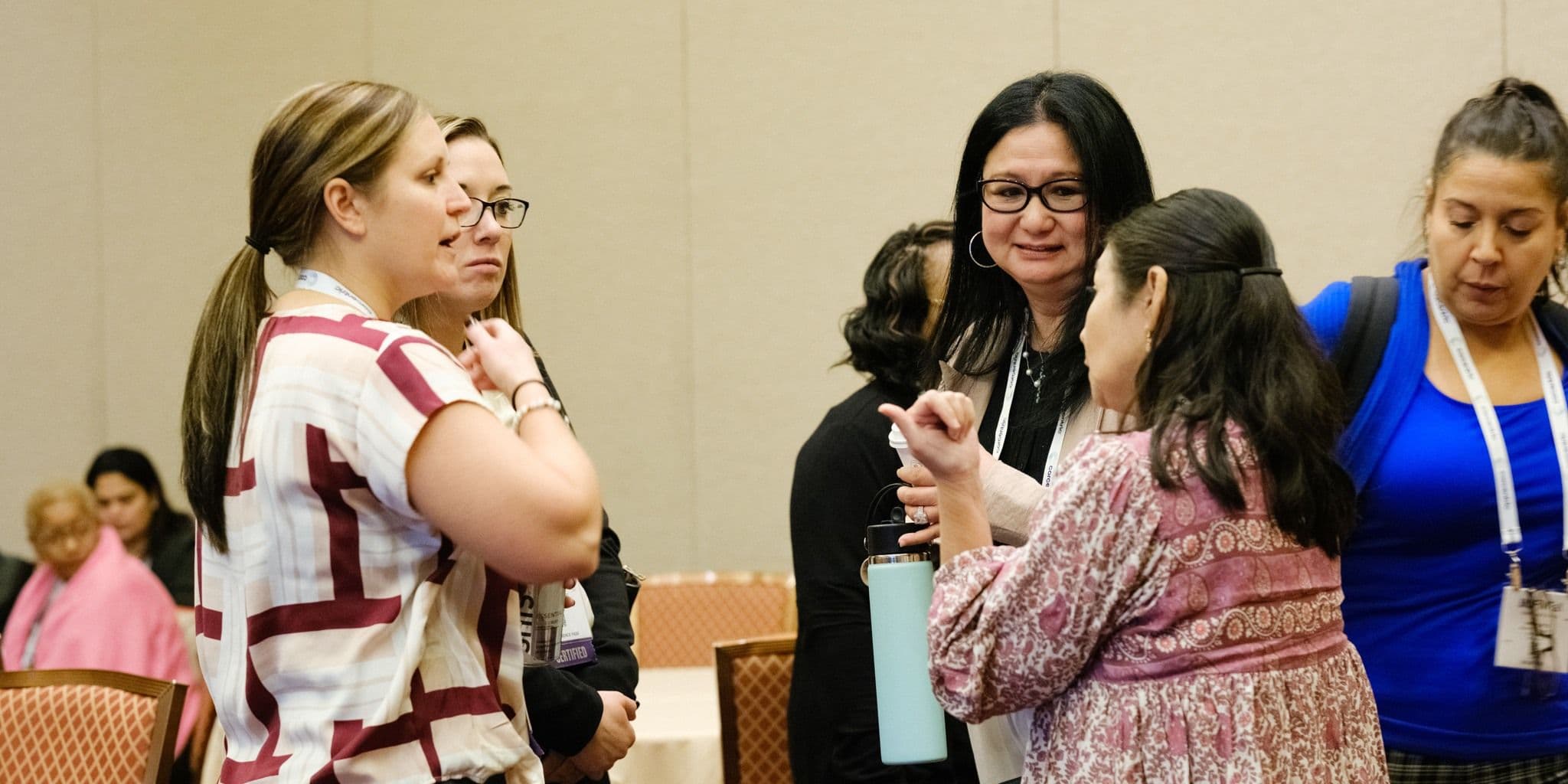 Attendees talking in a conference room at IOFM Fall 2024.