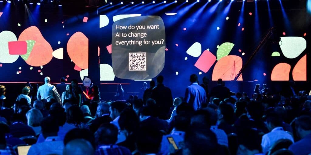 Attendees facing an interactive keynote screen