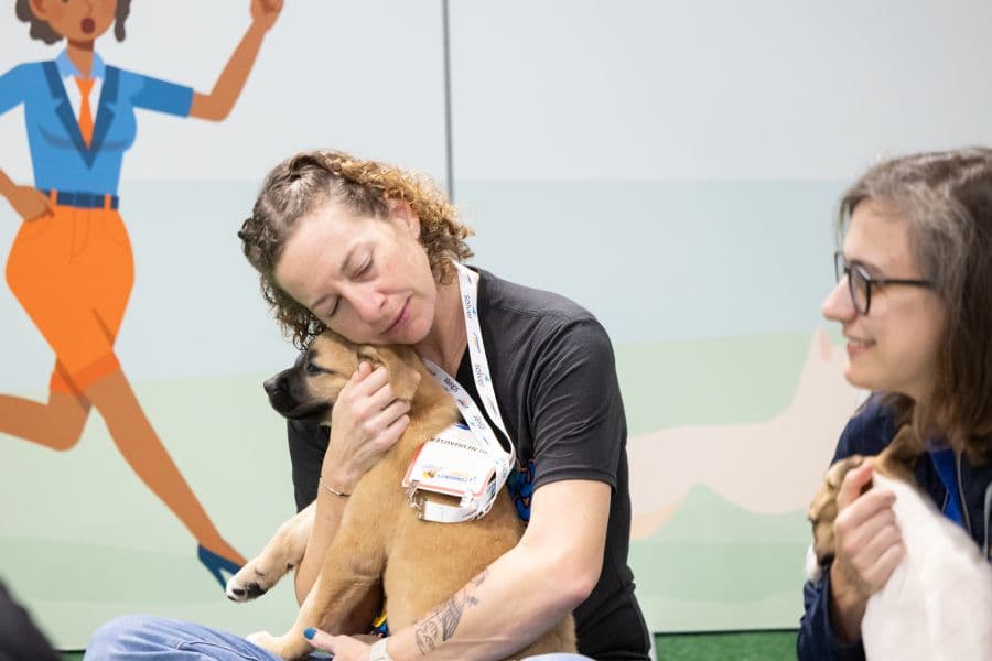 Community Summit attendee holding a rescue puppy during the 2025 event