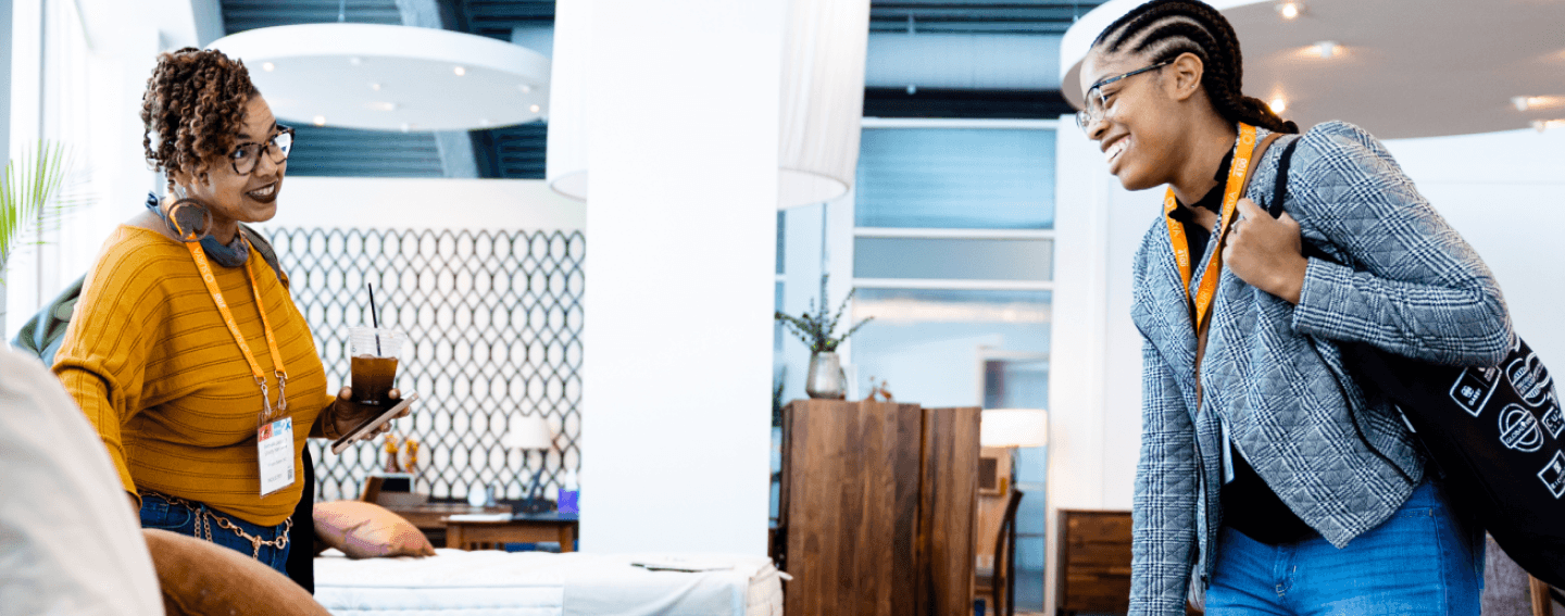 Two High Point Market attendees talk inside a furniture showroom during the Spring 2023 edition.