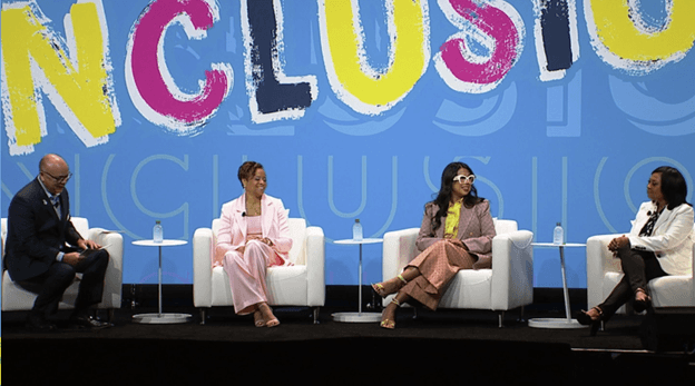 Four panelists seated on stage in front of a large INCLUSION backdrop at SHRM INCLUSION 2023.