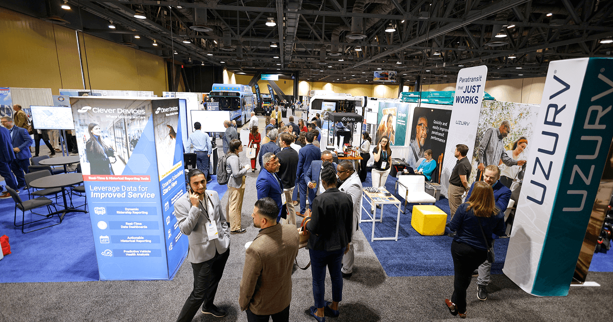 Visitors moving through transit exhibitor booths