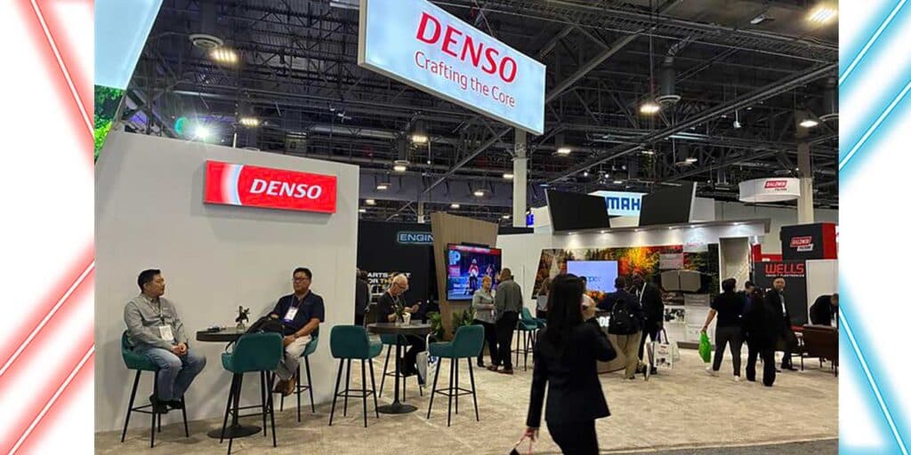 Denso staff and visitors talking at the AAPEX 2025 booth