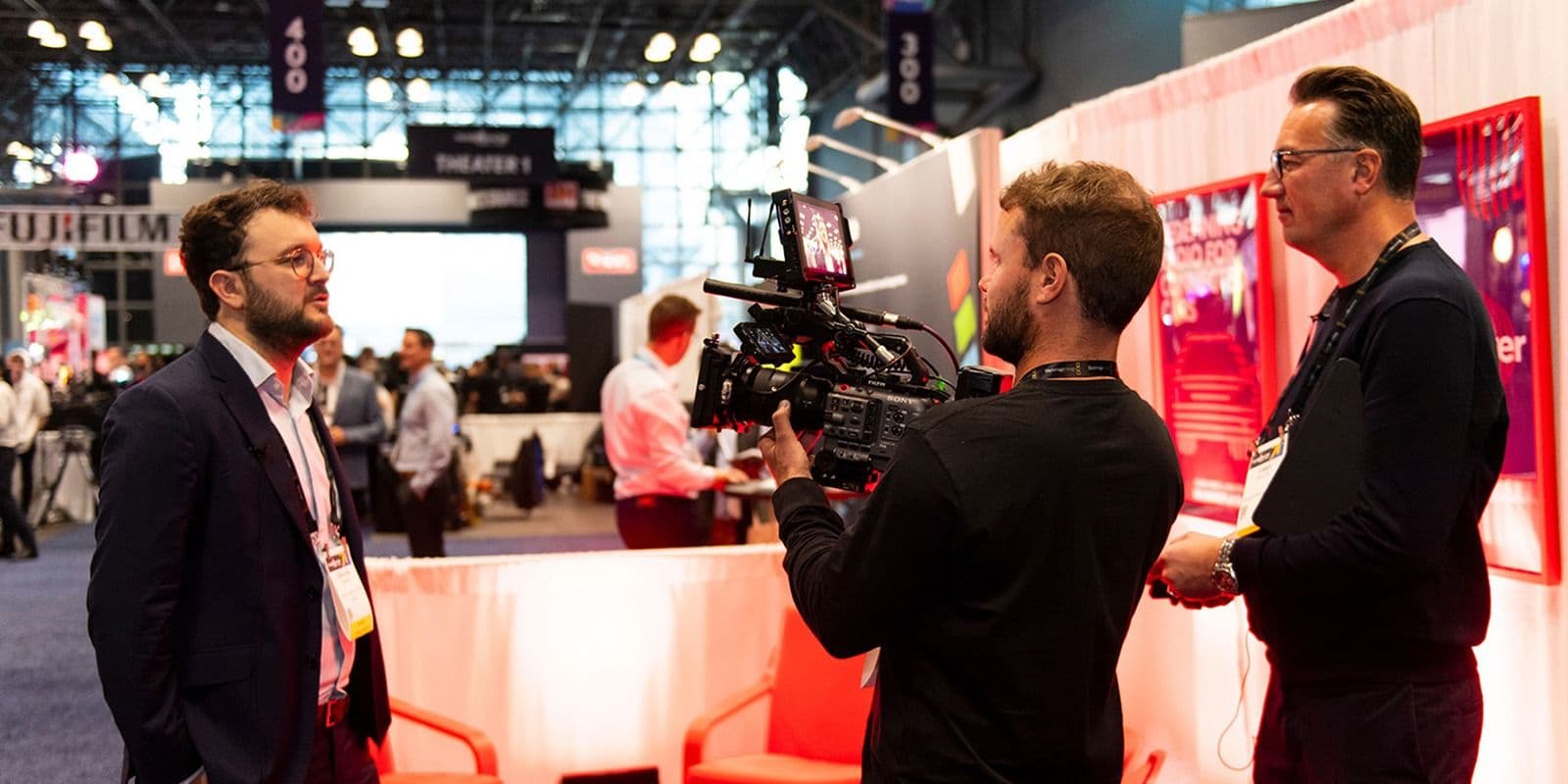 Camera operator filming an interview on the NAB Show New York 2024 exhibition floor