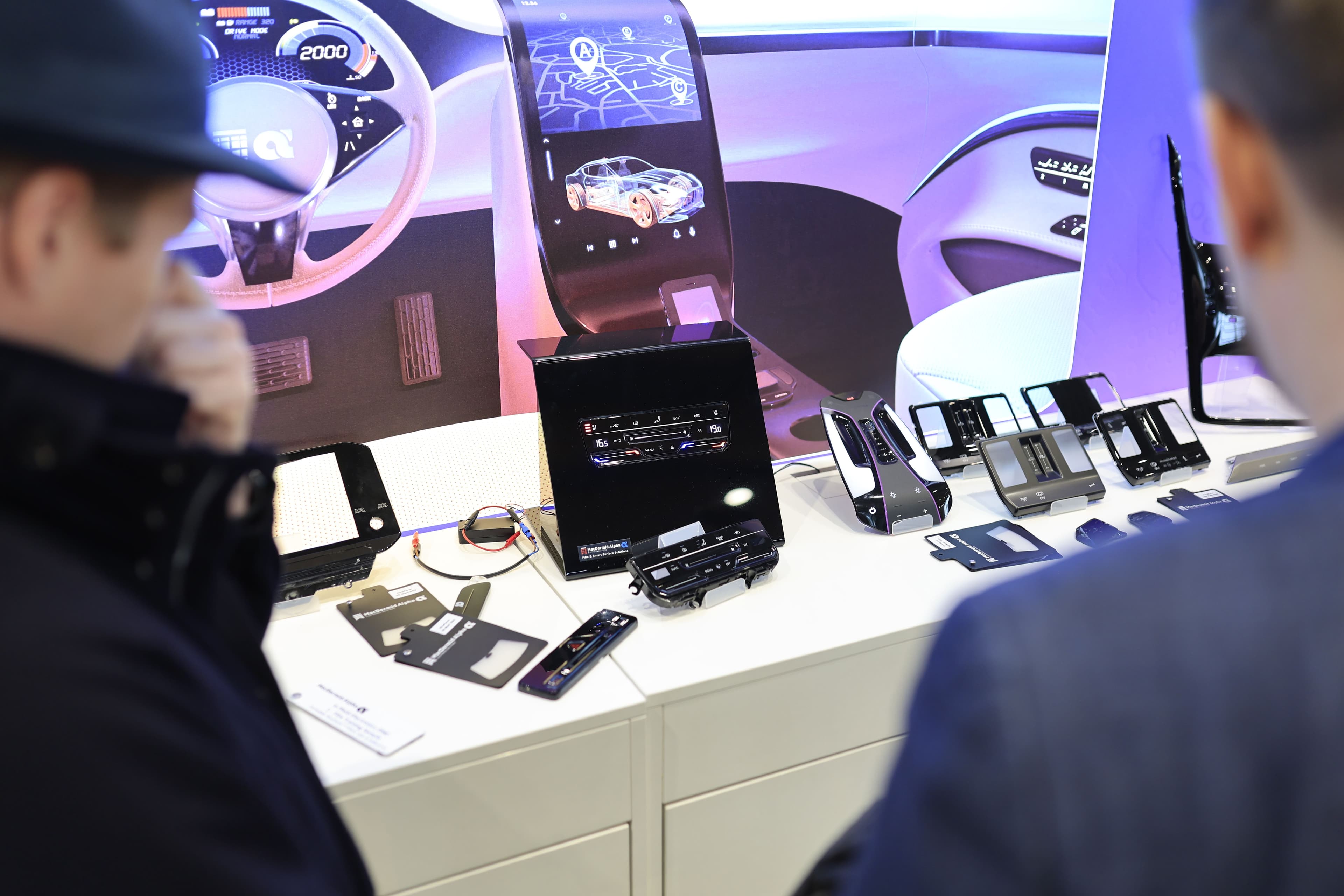 Visitors examine a vehicle cockpit and control display at the prior North America expo