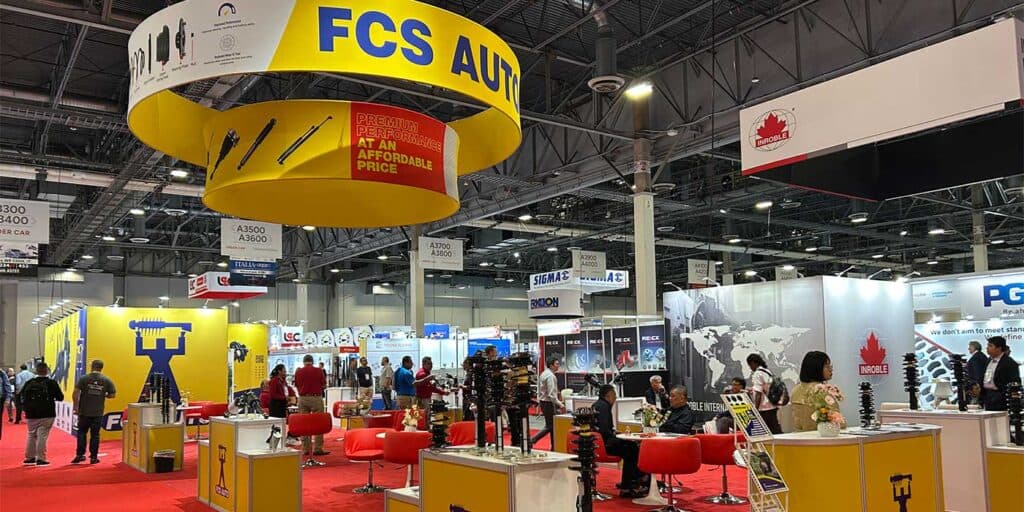 AAPEX 2025 booth display with visitors and automotive parts