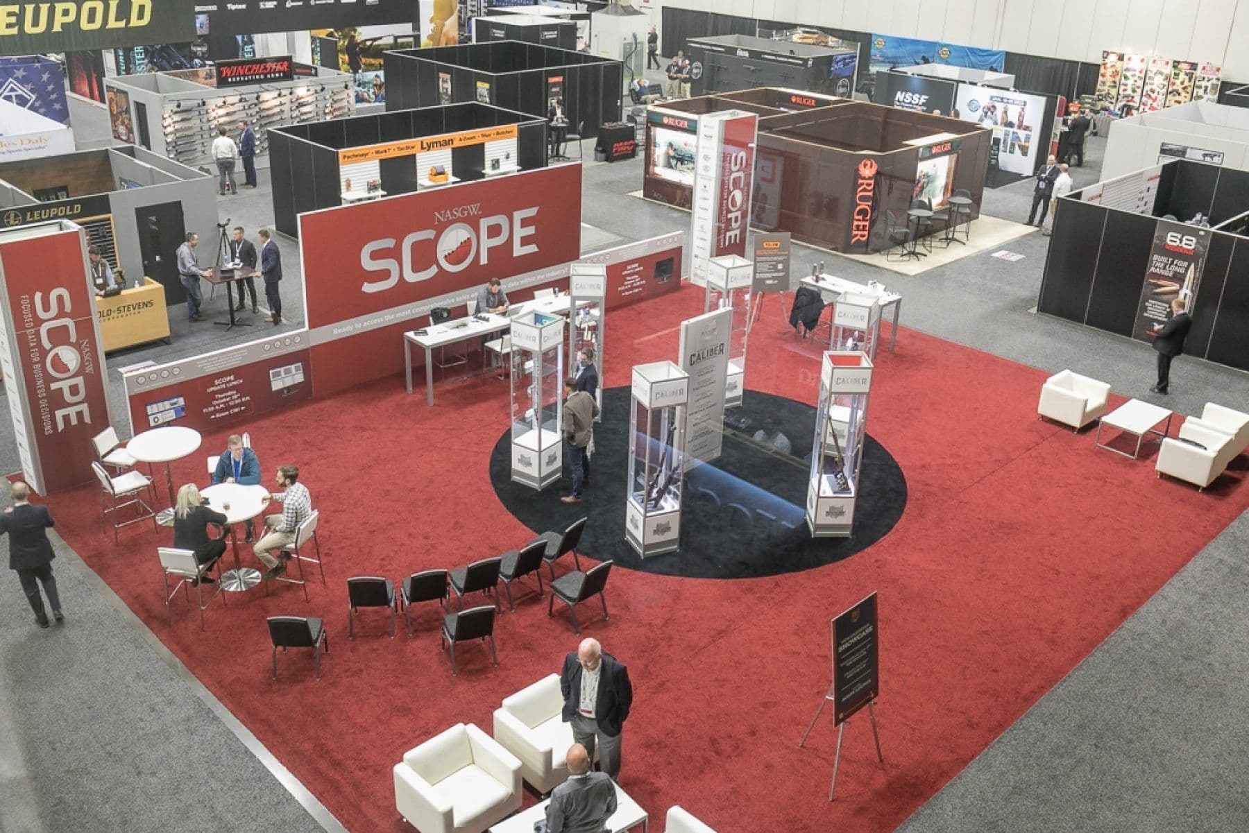 NASGW SCOPE lounge and Caliber display cases on the NASGW Expo 2021 show floor in Columbus, Ohio, with a Ruger booth behind
