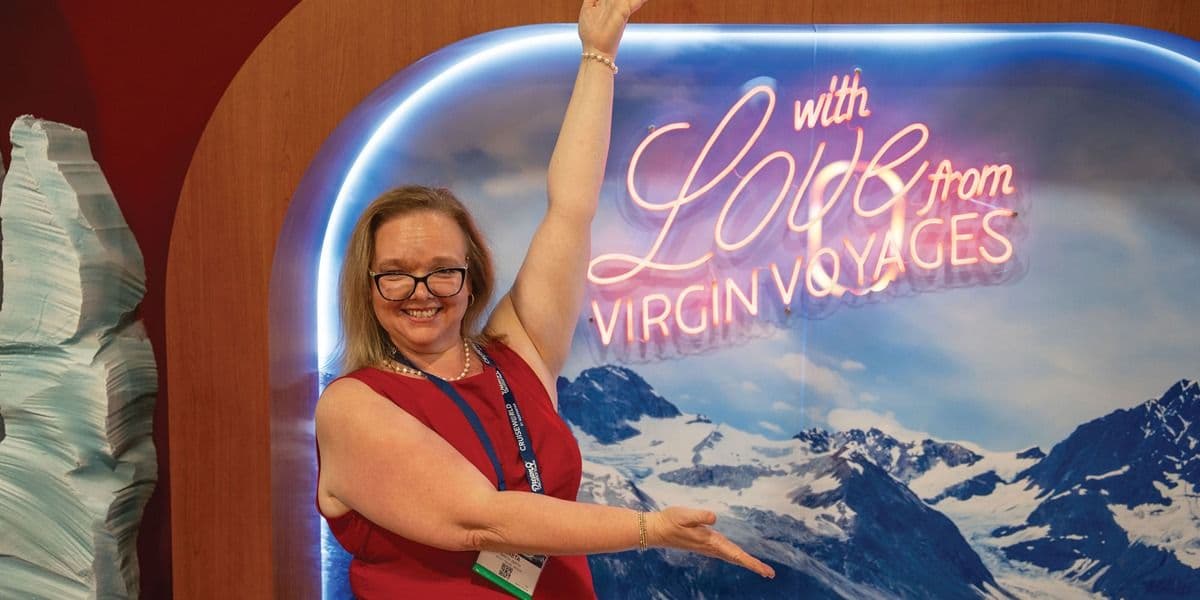 Travel advisor beside the Virgin Voyages display at CruiseWorld 2025