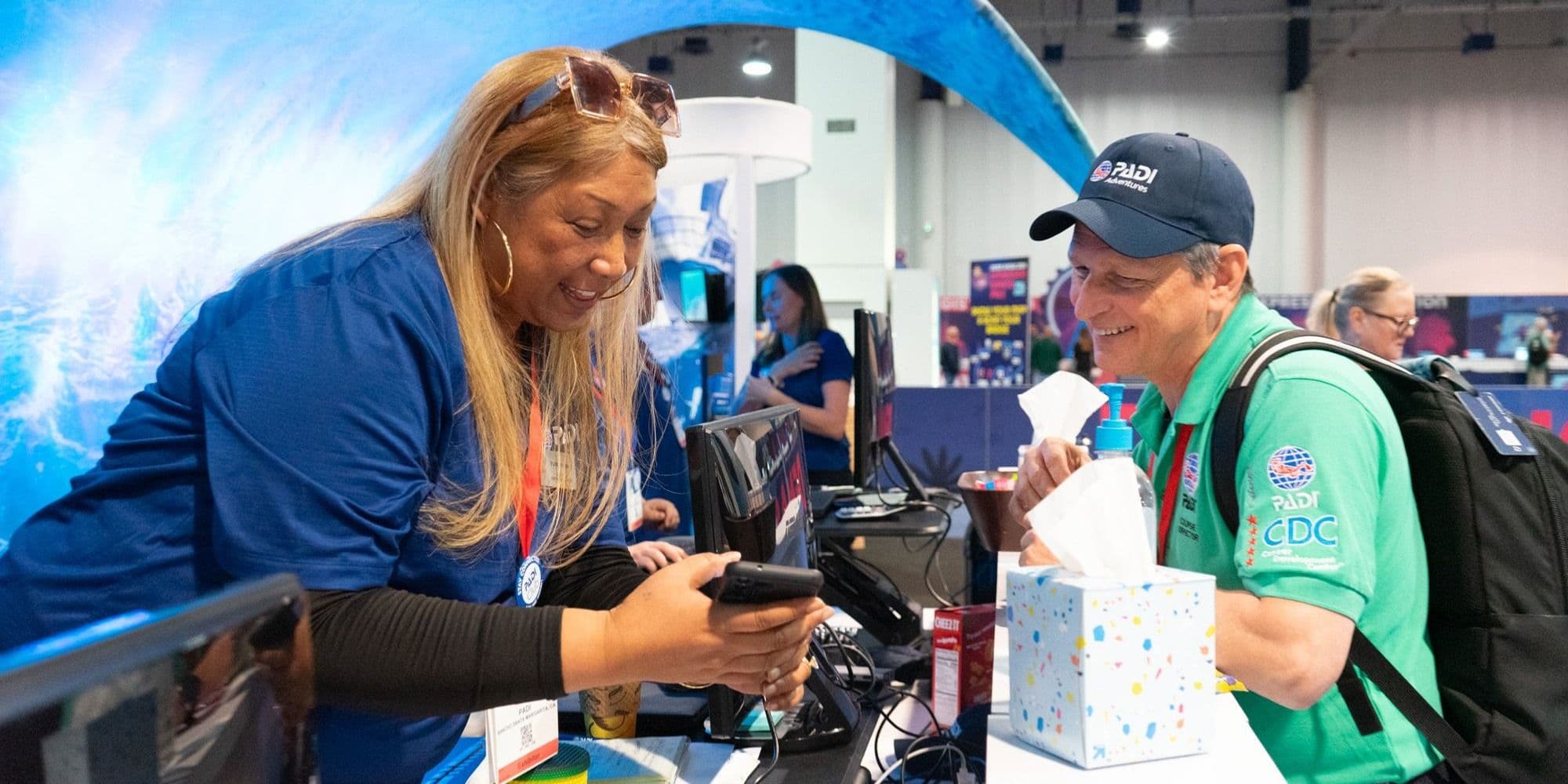 DEMA Show 2024 exhibitor and visitor speaking at a booth