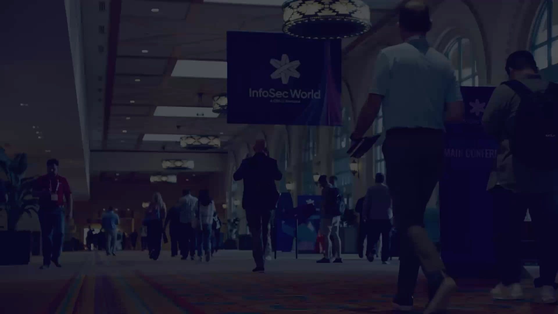 Attendees walk past branded InfoSec World event signage