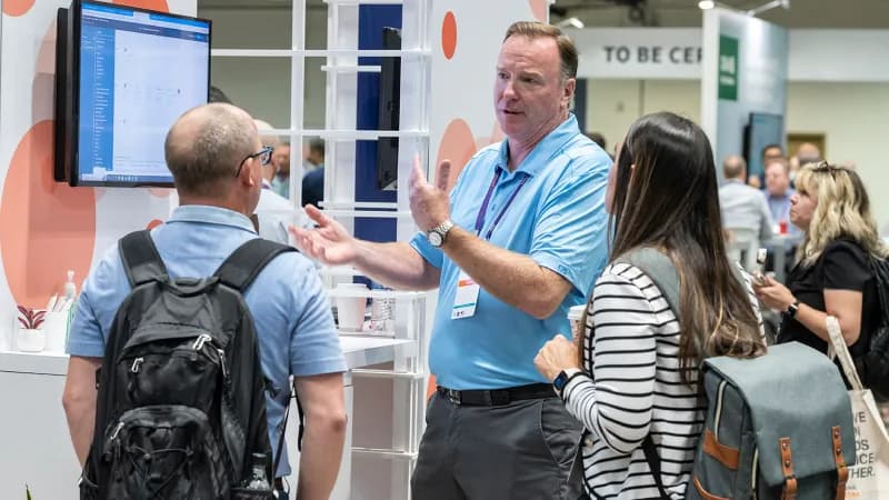 Attendees speaking with an exhibitor on the Gartner IT Symposium/Xpo show floor